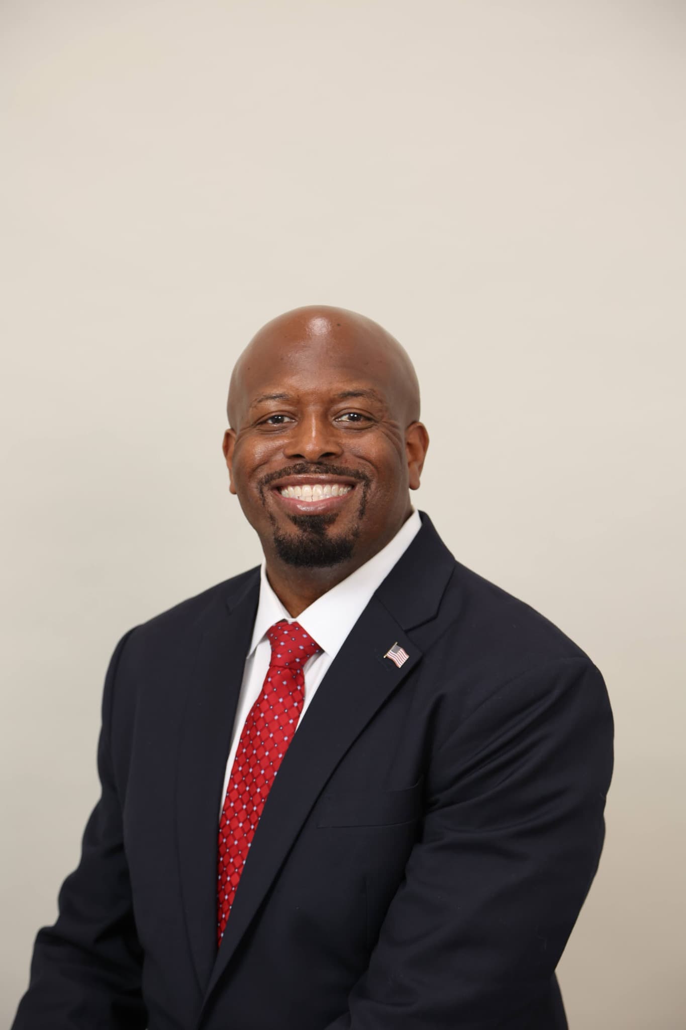 Brandon K. Taylor wearing a navy suit and red tie